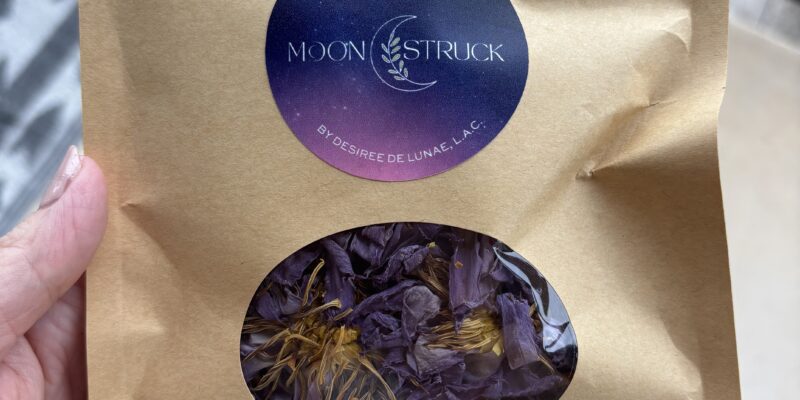 A custom circular vinyl logo sticker with a galaxy gradient design applied to a brown kraft paper.