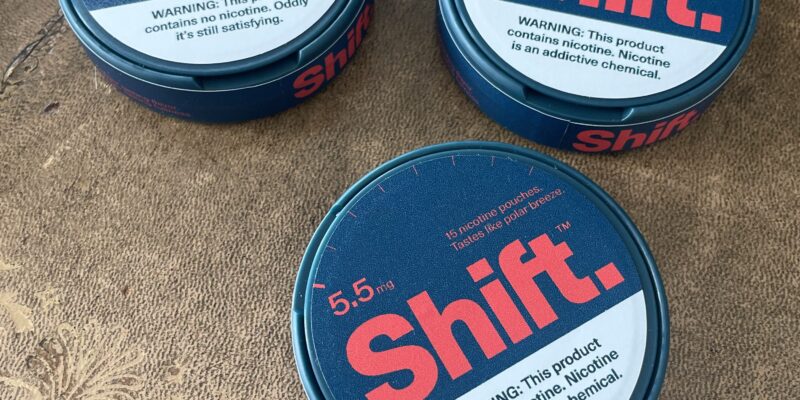 Three custom die-cut circular labels applied to round metal product tins, showcasing precision fit and professional matte finish.