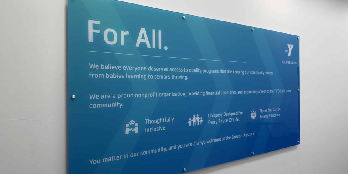 Custom acrylic wall hanging sign with standoffs and mission statement branding installed by our local print shop near me in Austin.